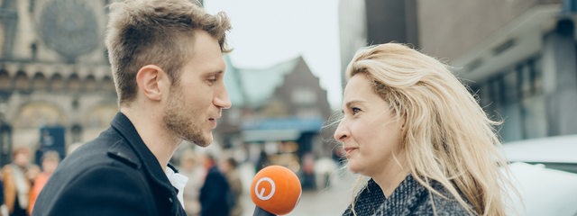 Reporter im Gespräch mit einer Frau